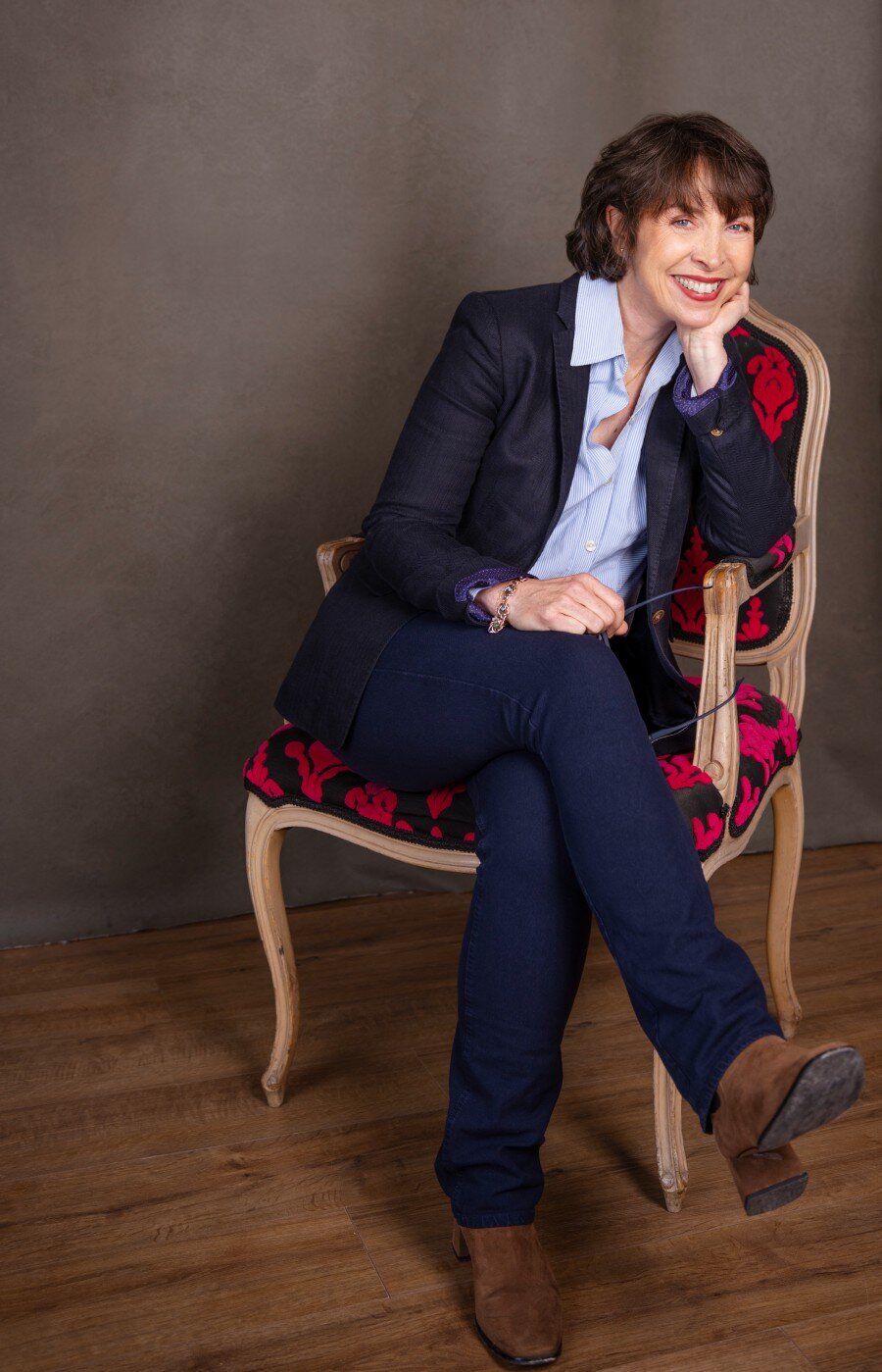 Vanessa Loughlin seated in an ornate chair in a relaxed, confident pose
